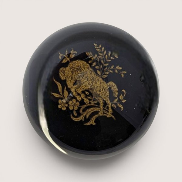 Vintage dome glass paperweight featuring an etched gold ram motif over a jet black lacquer background.