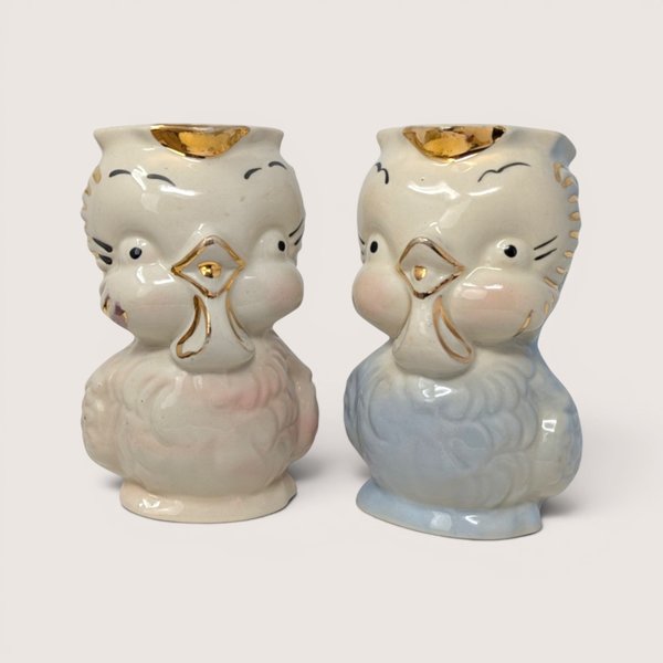 Vintage 1940s Shawnee Pottery ceramic owl creamer pitchers in pastel pink and blue with gold trim accents.