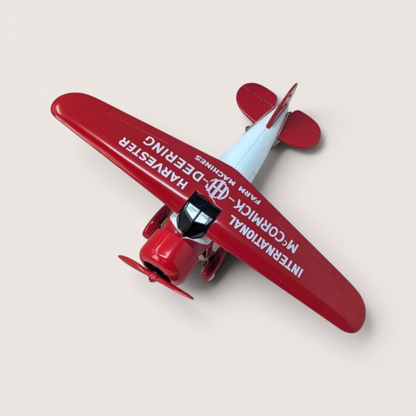 Top view of red and white die-cast 1932 Lockheed Vega airplane bank with International Harvester McCormick-Deering branding.