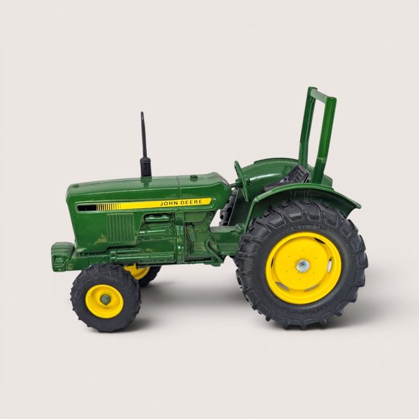 Vintage ERTL 1/16 scale diecast John Deere utility tractor in green and yellow with safety roll bar.
