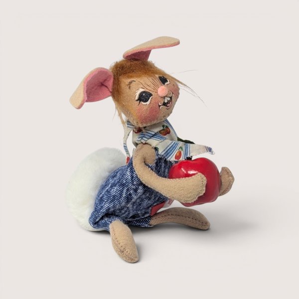 Vintage 1995 Annalee felt bunny doll wearing denim overalls and holding a red apple.