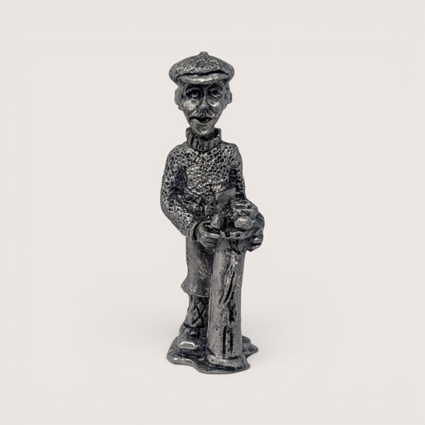 Vintage handcrafted pewter golfer figurine wearing a patterned sweater and cap while holding vintage golf clubs.