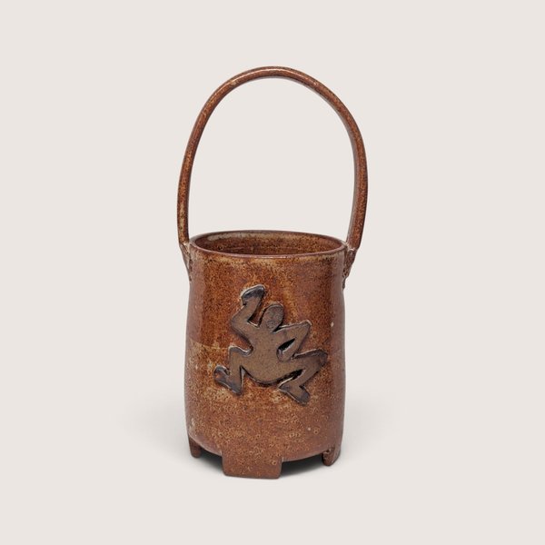 Vintage handmade stoneware pottery basket with a brown speckled glaze and an applied frog figure on the side.