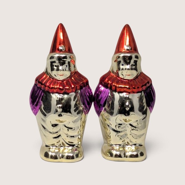 Vintage 1950s clown salt and pepper shakers with metallic finishes, red hats, and ruffs.