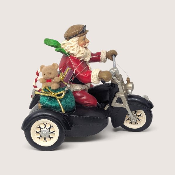 Vintage 1990s plastic Santa on motorcycle ornament with sidecar and fishing line strings.