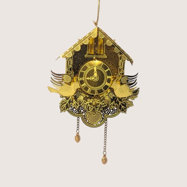 Vintage gold-tone laser-cut metal cuckoo clock ornament featuring hanging chains, dimensional birds, and a slot for a tree light.