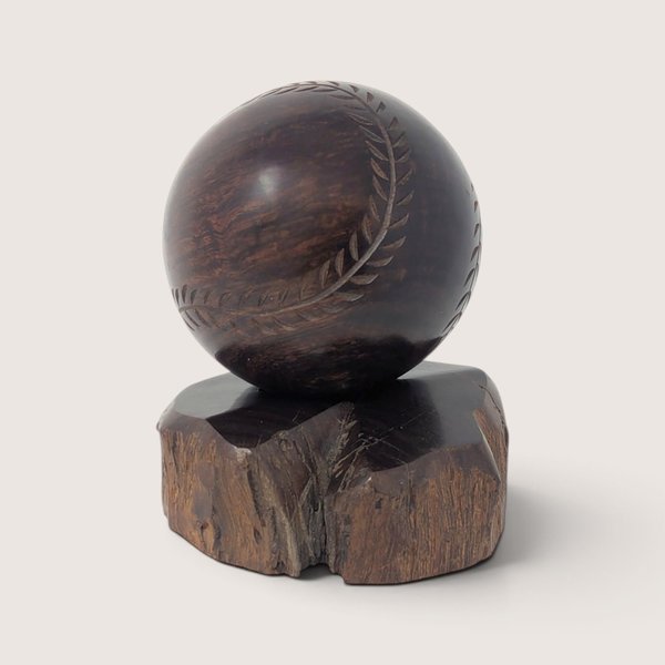 Vintage hand-carved wooden baseball display figurine resting on a natural wood base.
