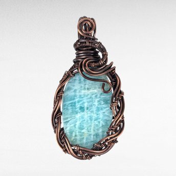 Copper wire wrapped amazonite cabochon.