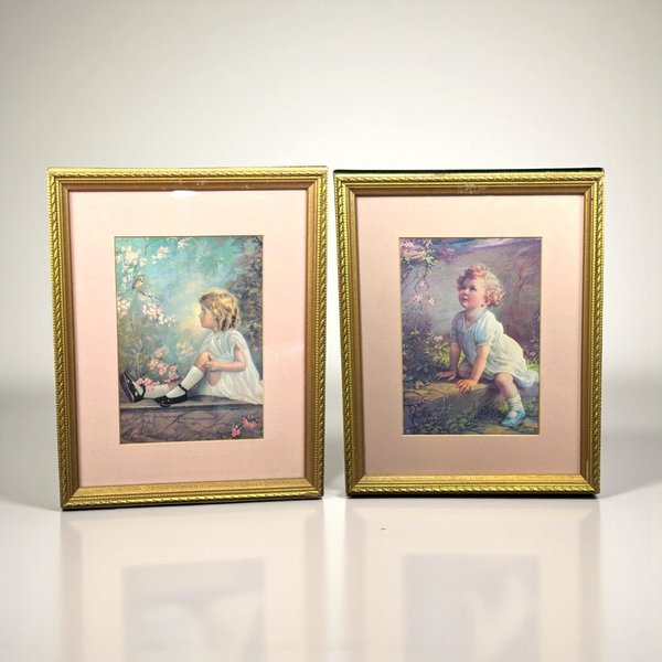 Two matching vintage wood frames containing portrait prints of little girls. One print, "Song of the Bluebird" by Zula Kenyon, shows a girl in a soft dress looking upward at a bird. The second, "Song of the Lark" by Florence Lindsey, features a similar ethereal portrait. The frames have a dark, aged finish with ornate period detailing.