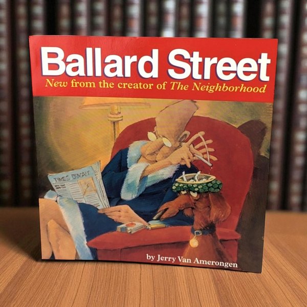 A square 8-inch softcover book titled "Ballard Street" featuring a colorful cartoon illustration of an elderly man in a blue robe sitting in a red armchair next to a dog wearing an ashtray on its head.