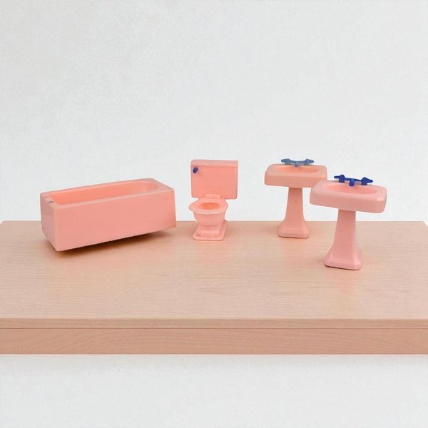 A collection of four miniature dollhouse bathroom fixtures in a uniform pastel pink. The set includes a rectangular bathtub, a toilet with a blue handle, and two pedestal sinks with blue faucets. All pieces feature smooth, rounded edges and a soft matte finish.