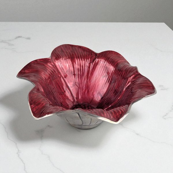 A sculptural bowl shaped like a blooming flower, featuring a lustrous interior of iridescent pink enamel infused with crushed Mother of Pearl. The exterior is made of textured, sand-cast aluminum with a soft metallic sheen.