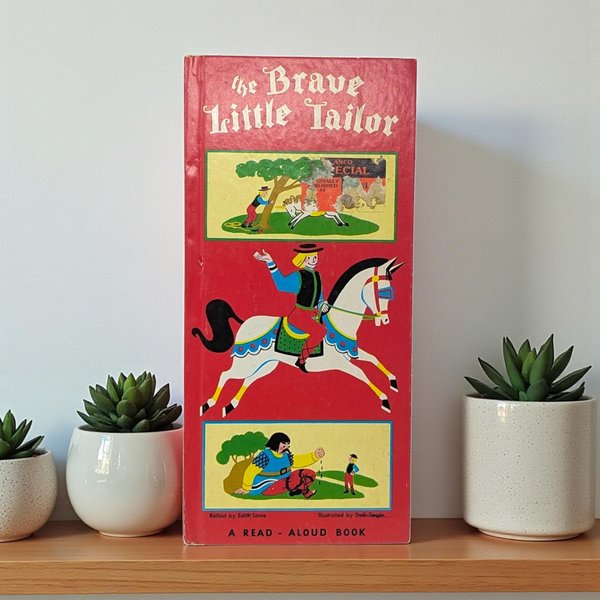 A tall, rectangular vintage children's book titled The Brave Little Tailor. The cover is vibrant red with three stacked illustrations featuring a knight on a white horse and a giant. The finish is matte paper with a smooth, aged texture.