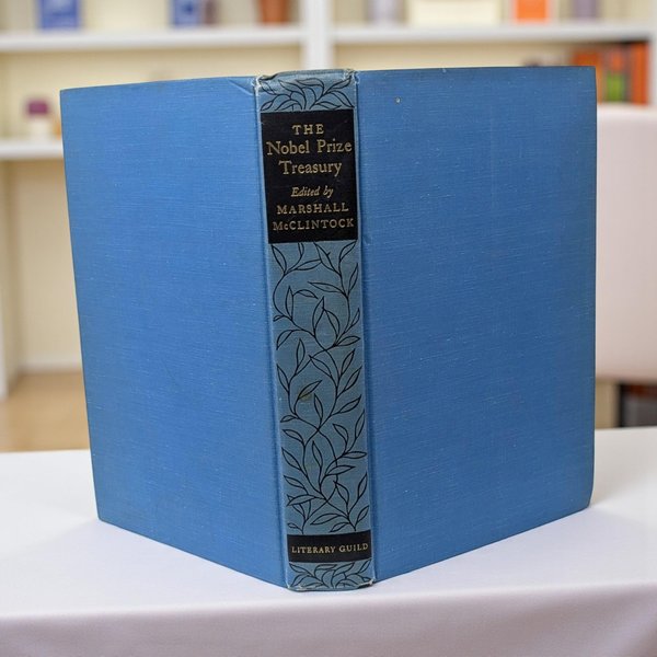 A hardcover book featuring a vibrant cornflower blue cloth binding with a textured linen finish. The spine is detailed with a black title block and delicate, interconnected leaf vine illustrations in black ink.