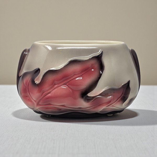 A rectangular ceramic planter with a sculptural raised leaf design. The body is finished in a warm beige speckled glaze, while the relief leaves are accented with a soft, airbrushed pinkish-red hue that creates a gentle gradient effect.